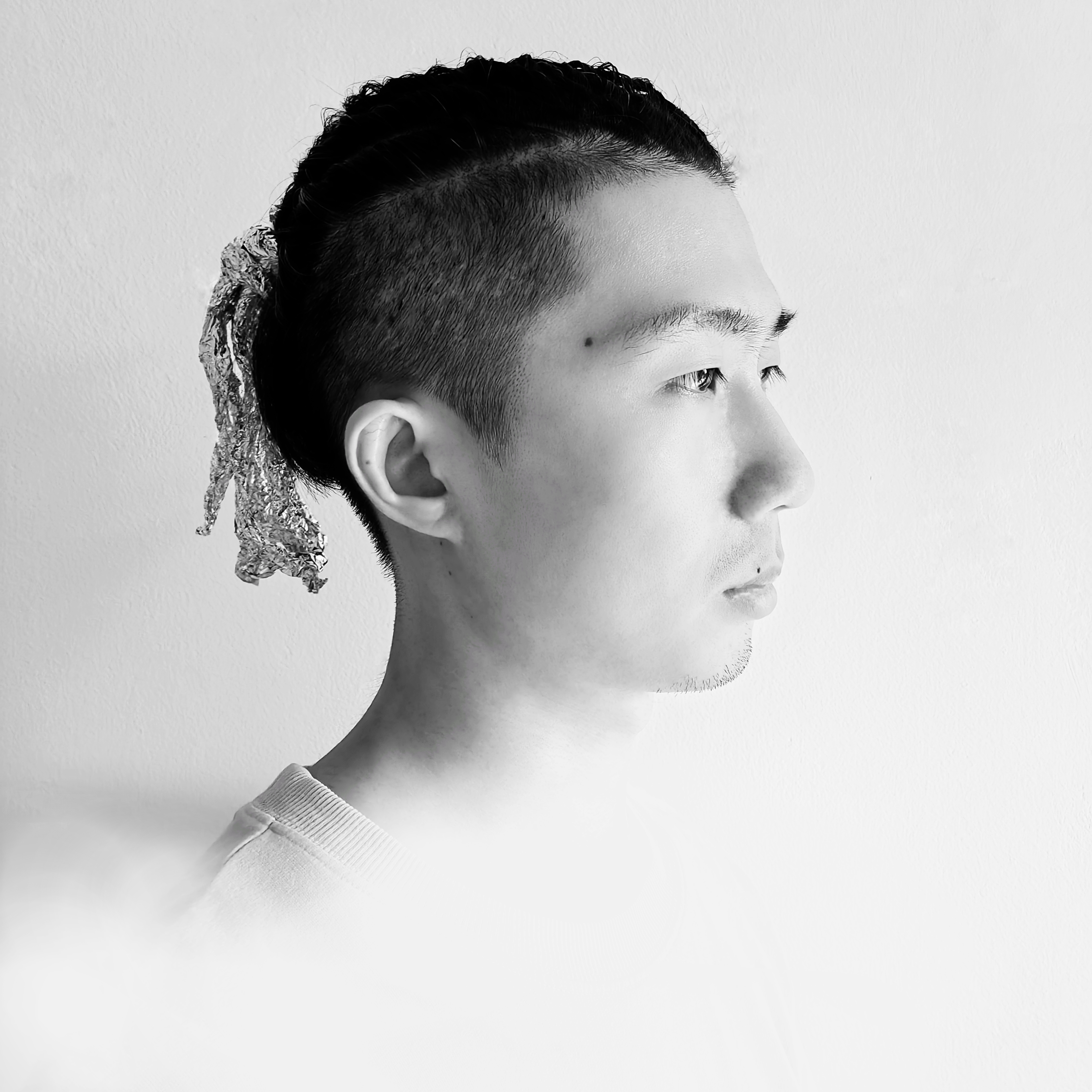 三十岁左右女性正面微笑头像,穿深灰色西装外套,白色衬衫,背景简洁明亮